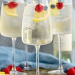 Photo of White Wine Spritzers garnished with lemon slices and berries.
