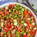 Pinterest graphic for Eggplant Salad recipe. Text says, "Grandma's Eggplant Salad simplejoy.com." Image is overhead photo of Eggplant Salad. Salad tongs and two tomatoes on counter beside bowl.