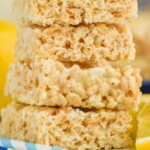 Pinterest graphic for Lemon Rice Krispie Treats recipe. Image is close up photo of a stack of Lemon Rice Krispie Treats. Text says, "super easy Lemon Rice Krispies simplejoy.com"