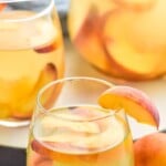 Pinterest graphic for Peach Sangria recipe. Text says, "the best Peach Sangria simplejoy.com." Image is photo of glasses of Peach Sangria garnished with peach slices.