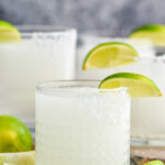 Close up photo of Frozen Margaritas garnished with lime slices.