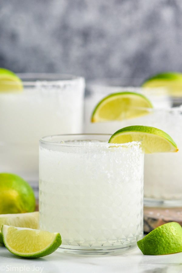 Close up photo of Frozen Margaritas garnished with lime slices.