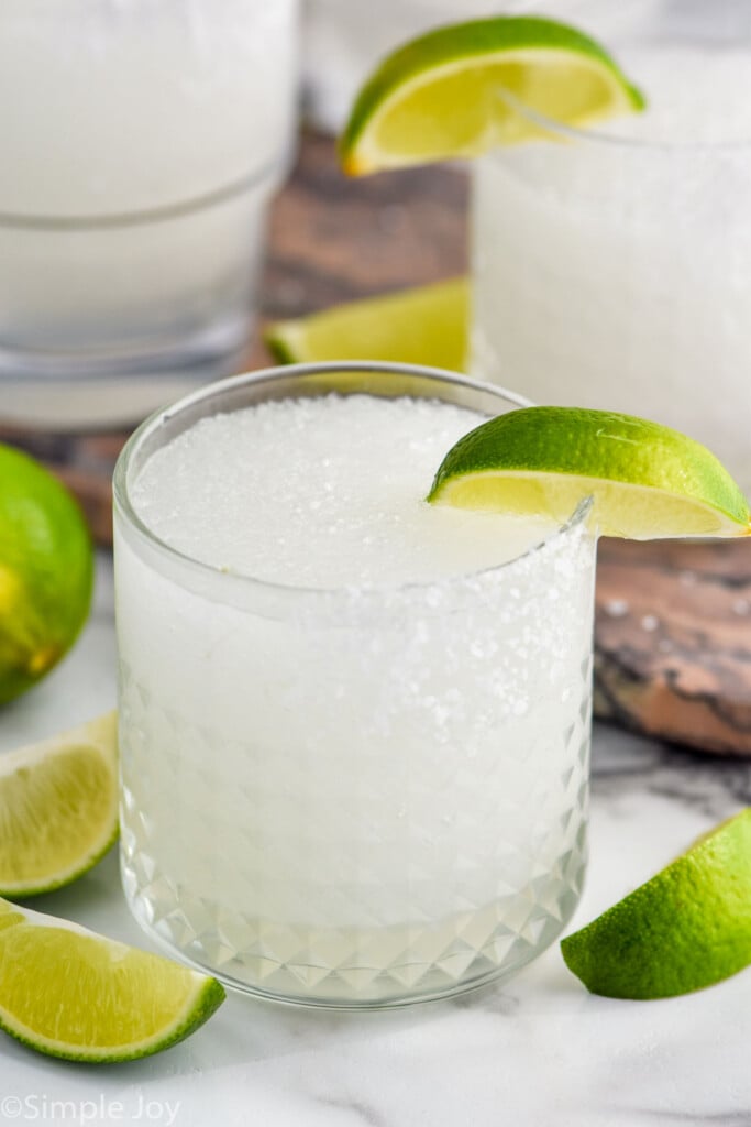 Close up photo of Frozen Margarita garnished with lime wedges.