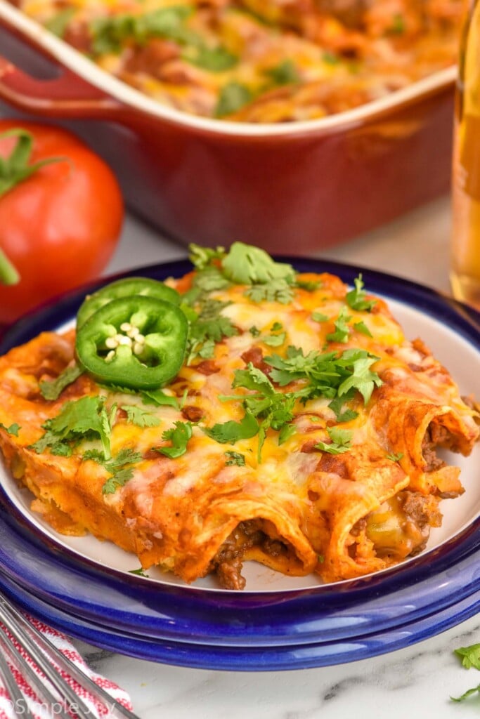 Close up photo of Beef Enchiladas served on a plate garnished with jalapenos and cilantro