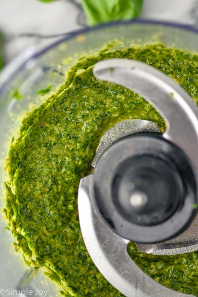 Overhead photo of food processor with ingredients for pesto sauce recipe.