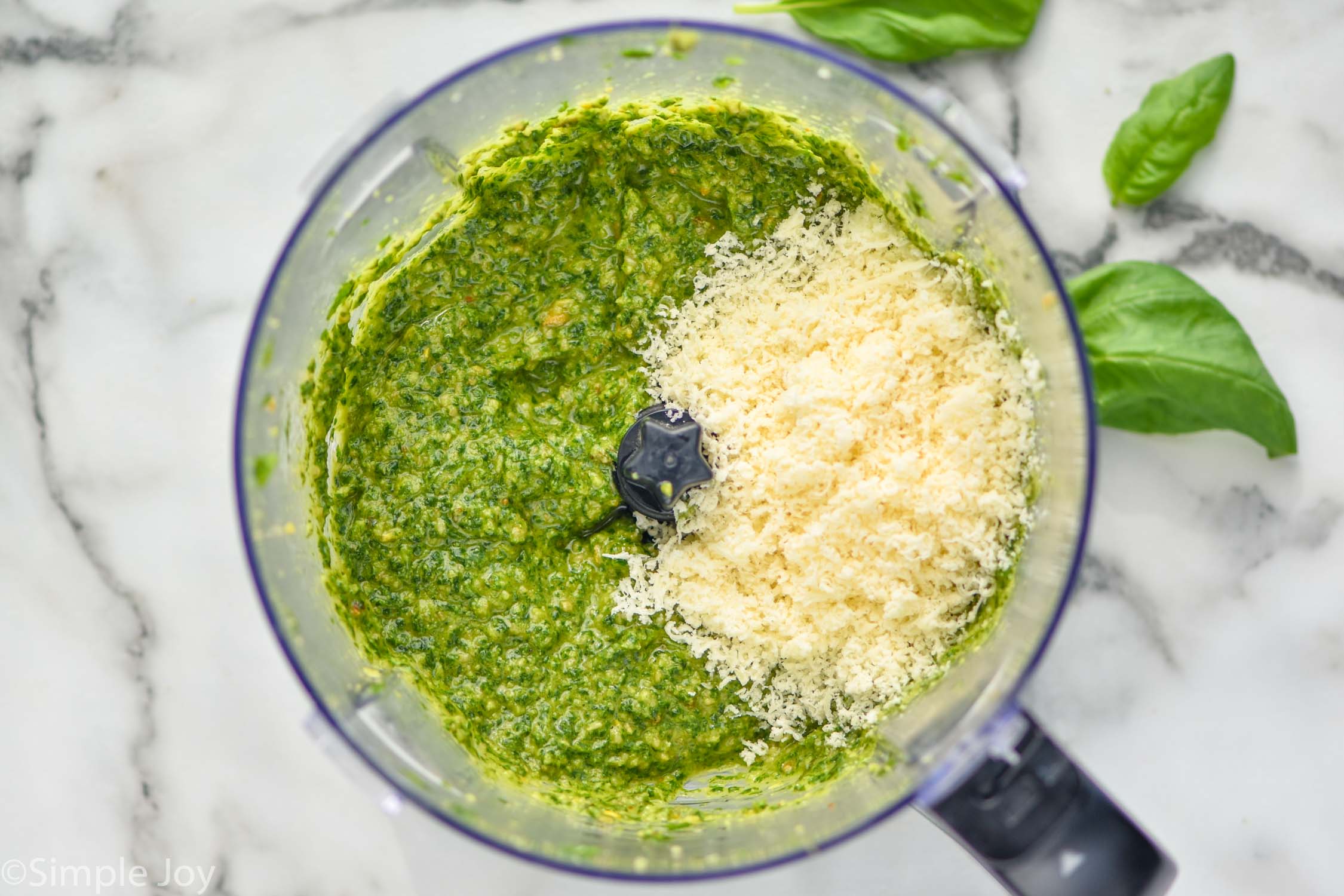 Overhead photo of a food processor of ingredients processed for Pesto Sauce Recipe.