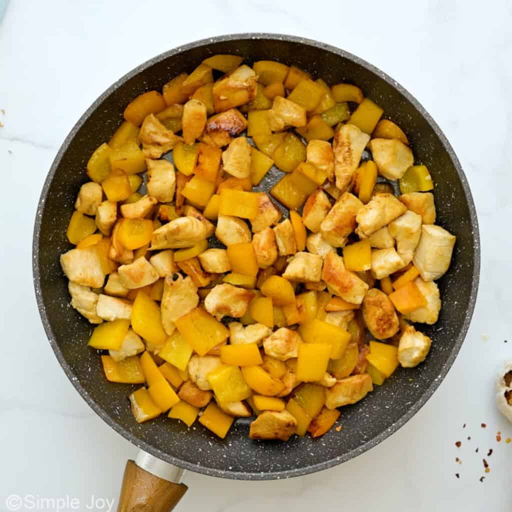 a skillet with sauteed chicken and bell peppers