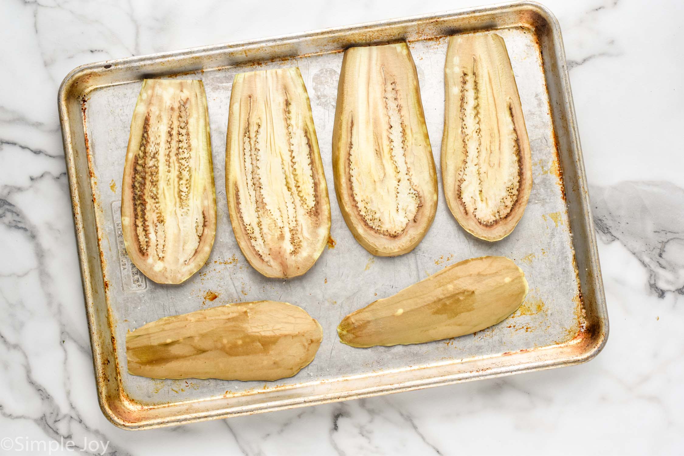 Overhead photo of prepared eggplant on baking dish for Eggplant Salad recipe.