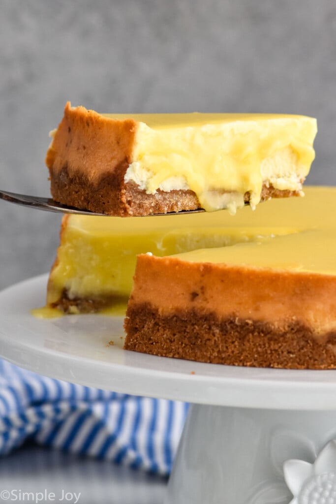 Photo of spatula serving a slice of Lemon Cheesecake from a platter of Lemon Cheesecake