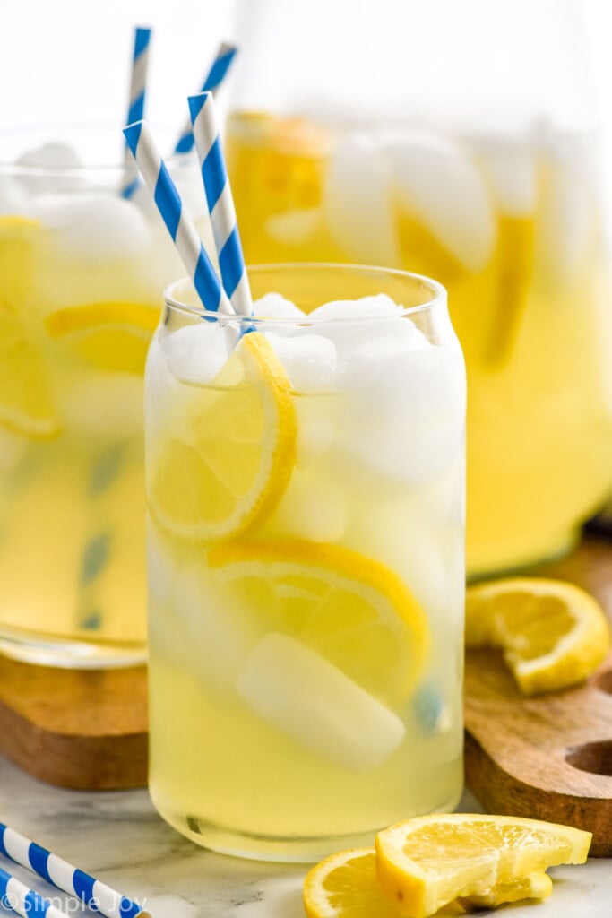 Photo of glasses of Lemonade garnished with lemon slices and straws for drinking.