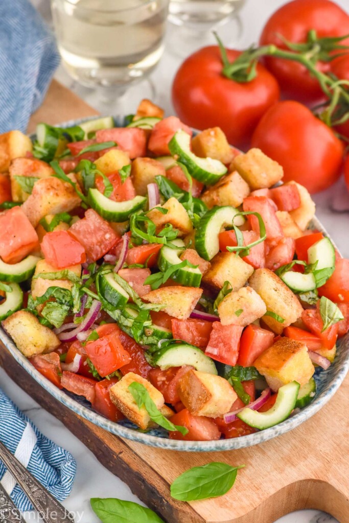 Side view of Panzanella Salad. Tomatoes next to bowl of Panzanella Salad.