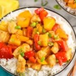 a bowl of pineapple chicken over a bowl of rice
