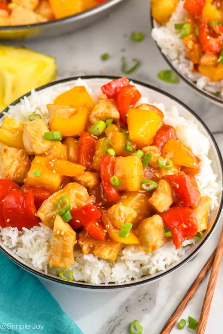 a bowl of pineapple chicken over a bowl of rice