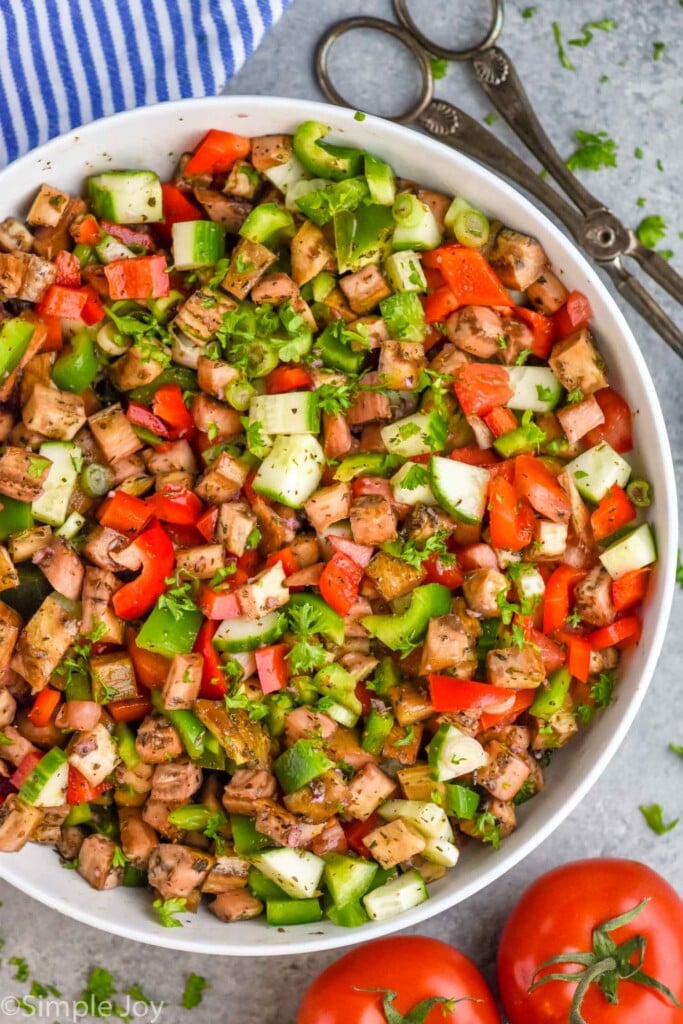 Overhead photo of Eggplant Salad with salad tongs beside bowl.