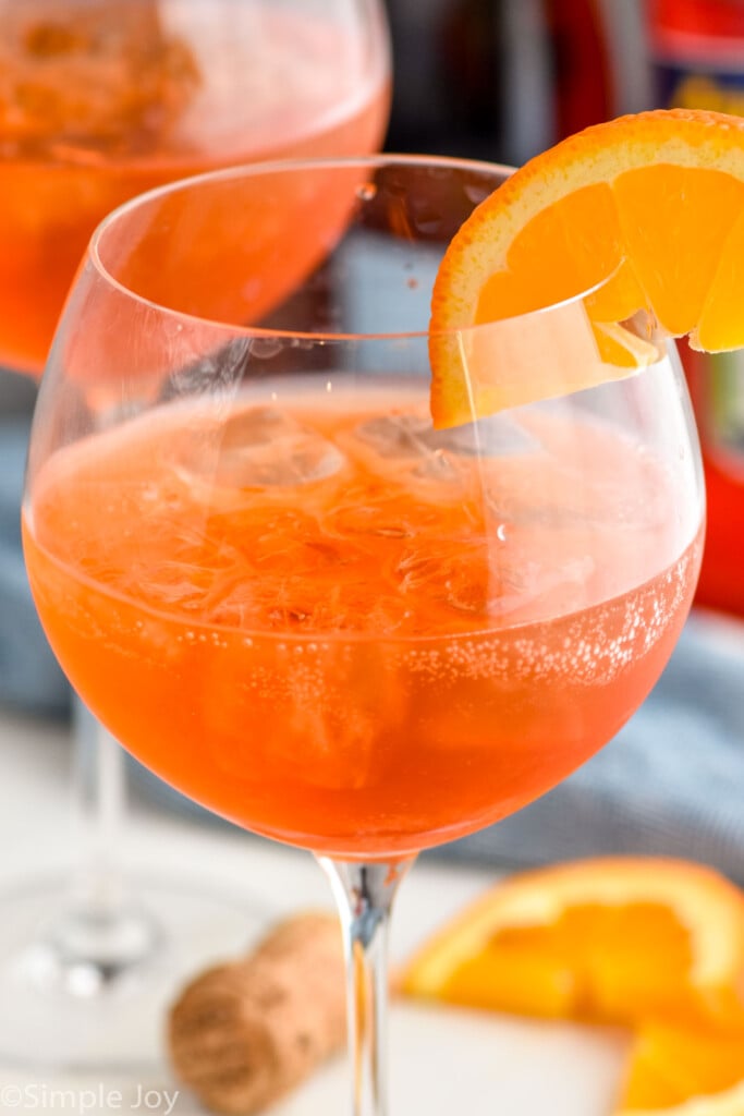 Close up photo of an Aperol Spritz garnished with orange slice.