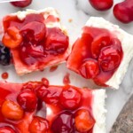 Pinterest graphic for cherry cheesecake bars. Text says "no bake cheesecake bars simplejoy.com" Images shows an overhead view of cherry cheesecake bars with cherries and serving spatula sitting beside.
