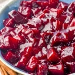 bowl of harvard beets with two cinnamon sticks sitting beside