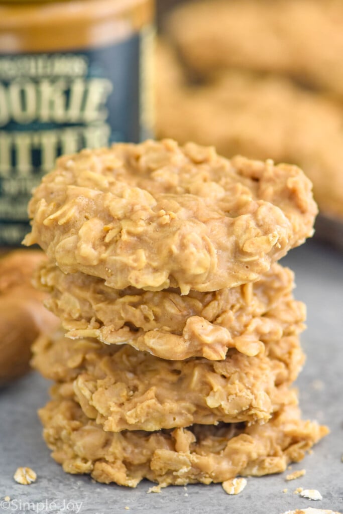 Stack of 4 No Bake Biscoff Cookies with jar of cookie butter sitting in background