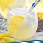 Pinterest graphic for Vodka Lemonade recipe. Image is side view of glasses of Vodka Lemonade garnished with lemon slices and straws. Text says, "Vodka Lemonade simplejoy.com"