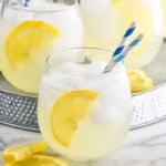 Pinterest graphic for Vodka Lemonade recipe. Image is side view of three glasses of Vodka Lemonade garnished with lemon slices and straws. Text says, "the best Vodka Lemonade simplejoy.com"