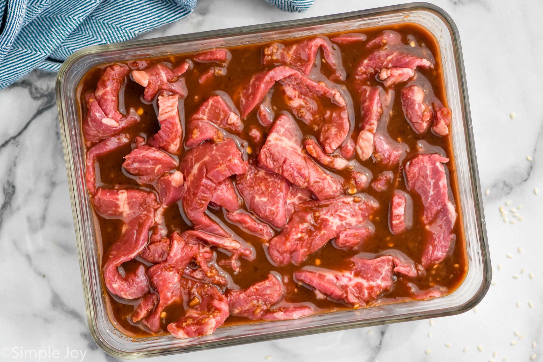 overhead view of pan of beef sitting in marinade ingredients for beef stir fry