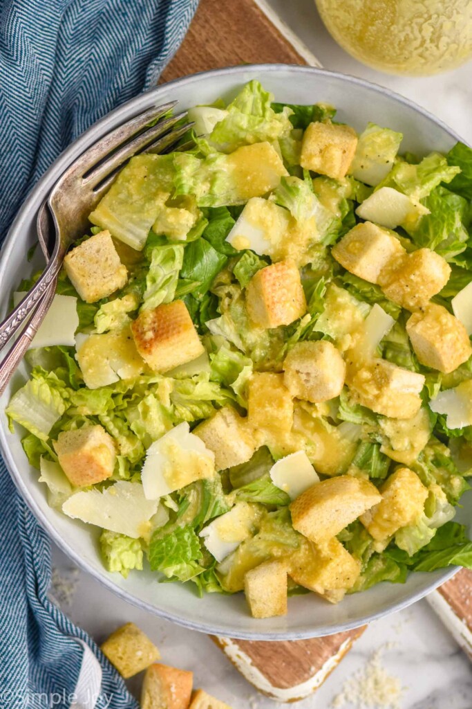 Bowl of Caesar salad topped with Caesar Dressing and croutons