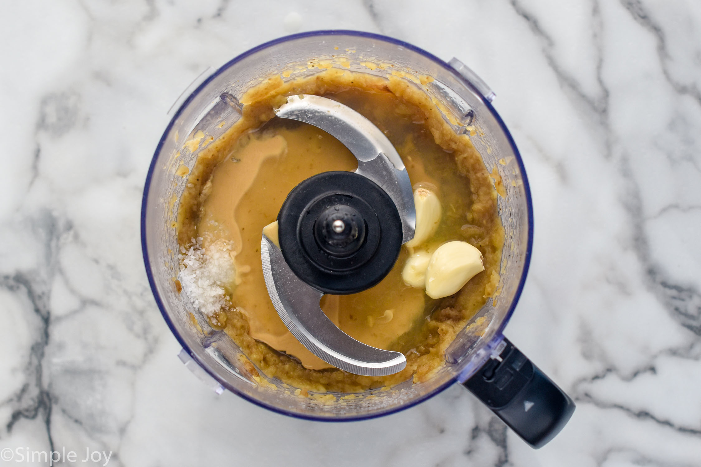 overhead of a food processor with Baba Ganoush ingredients