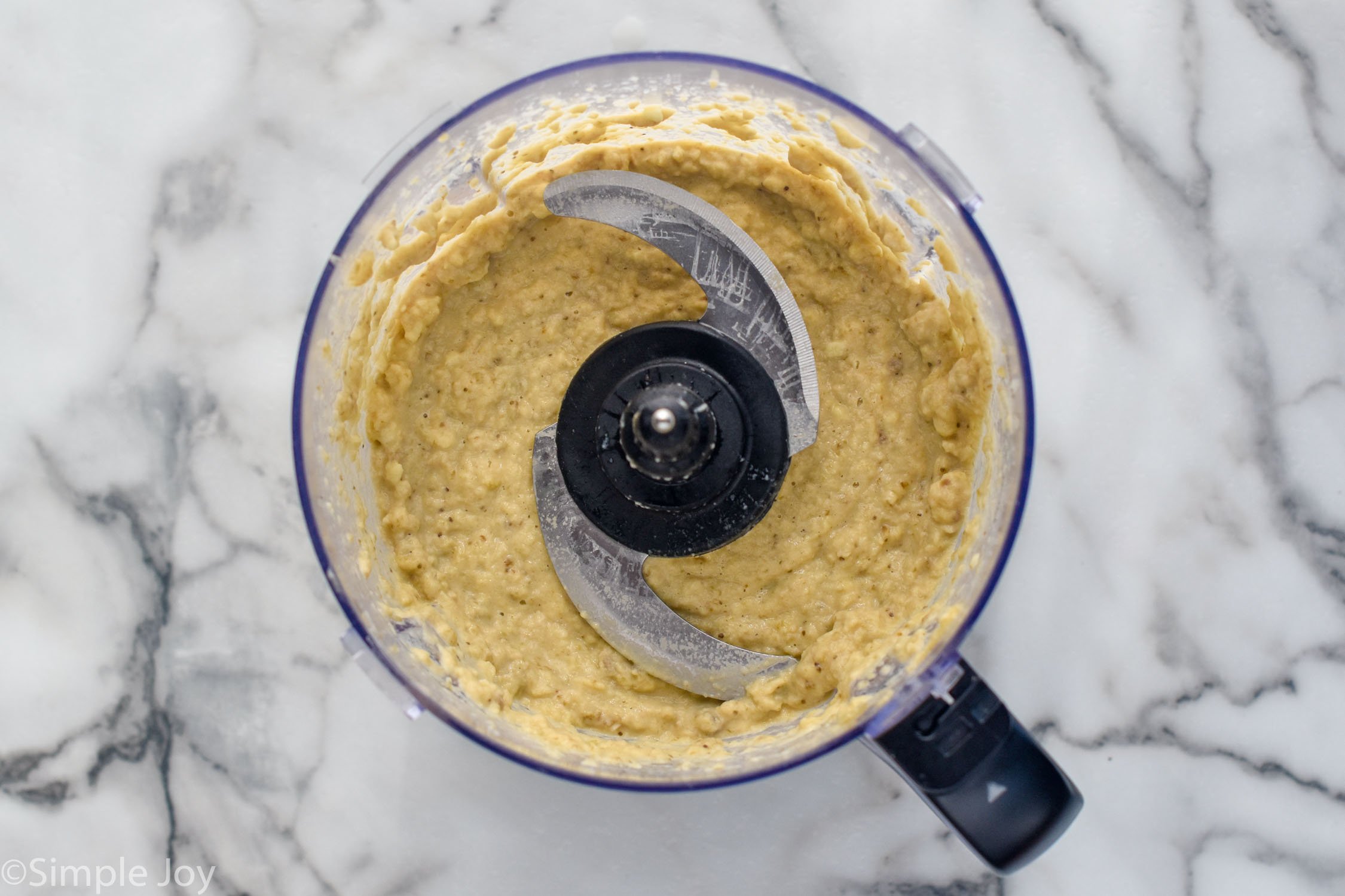 overhead view of a food processor with Baba Ganoush ingredients