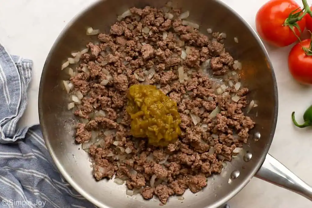 ground beef cooked in a skillet with green chiles