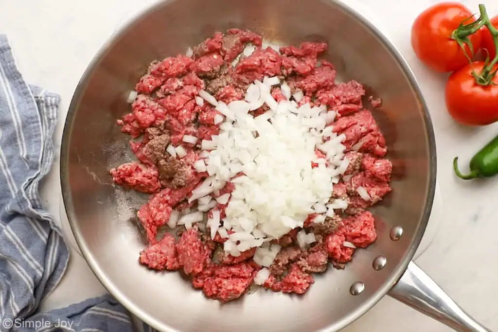 ground beef being browned in a skillet with diced onion