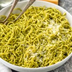 bowl of pesto pasta topped with parmesan cheese