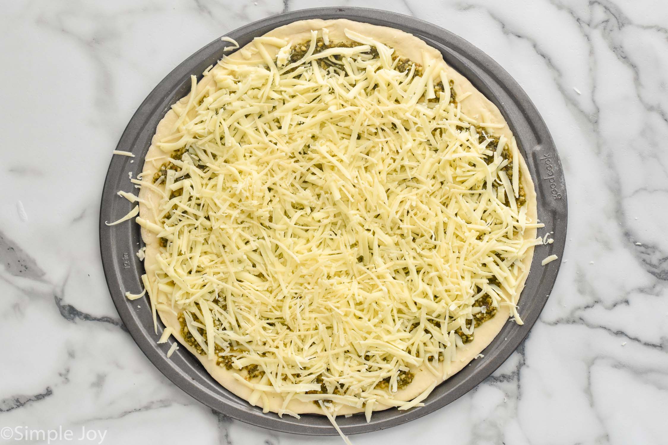 Overhead photo of ingredients on baking sheet for Pesto Pizza recipe.