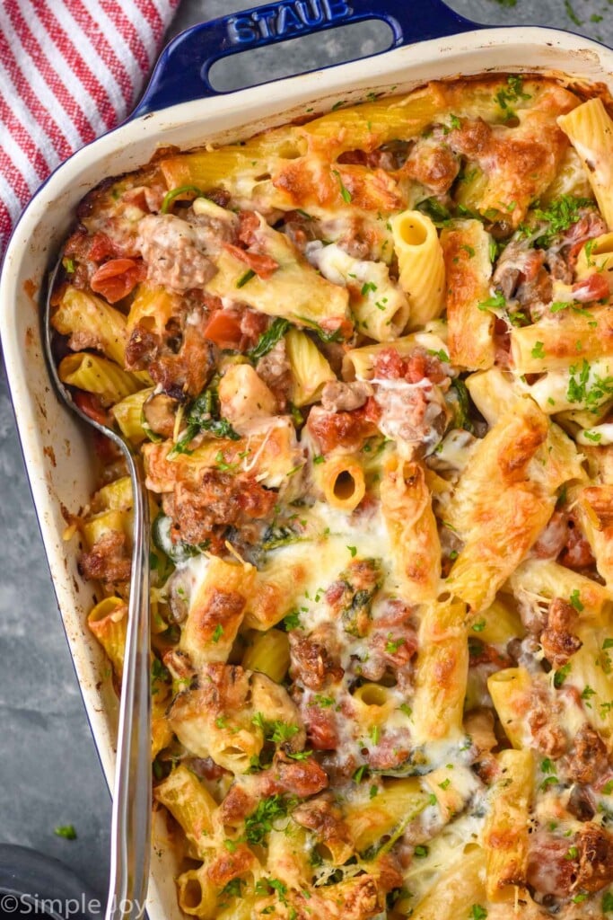 Overhead view of a baking dish of Baked Rigatoni with a spoon for serving.