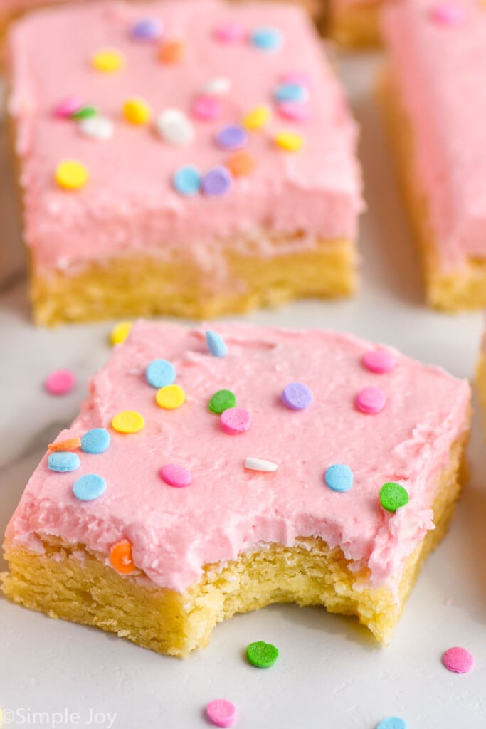 Side view of Sugar Cookie Bars. Front Sugar Cookie Bar has a bite taken out of it.