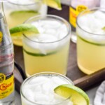 Pinterest image for Ranch Water. Text says "the best ranch water simplejoy.com" Image shows glasses of ranch water cocktail with ice and lime wedges. Bottle of topo chico sitting in background