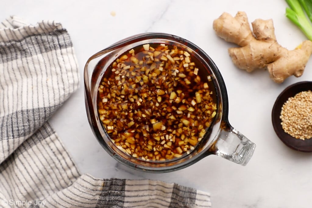 overhead of a measuring cup full of marinade for beef stir fry
