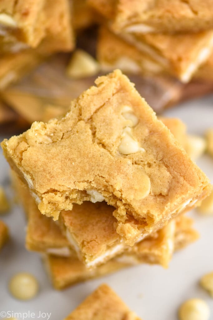 Overhead photo of a stack of blondies with a bite taken out of the top brownie.