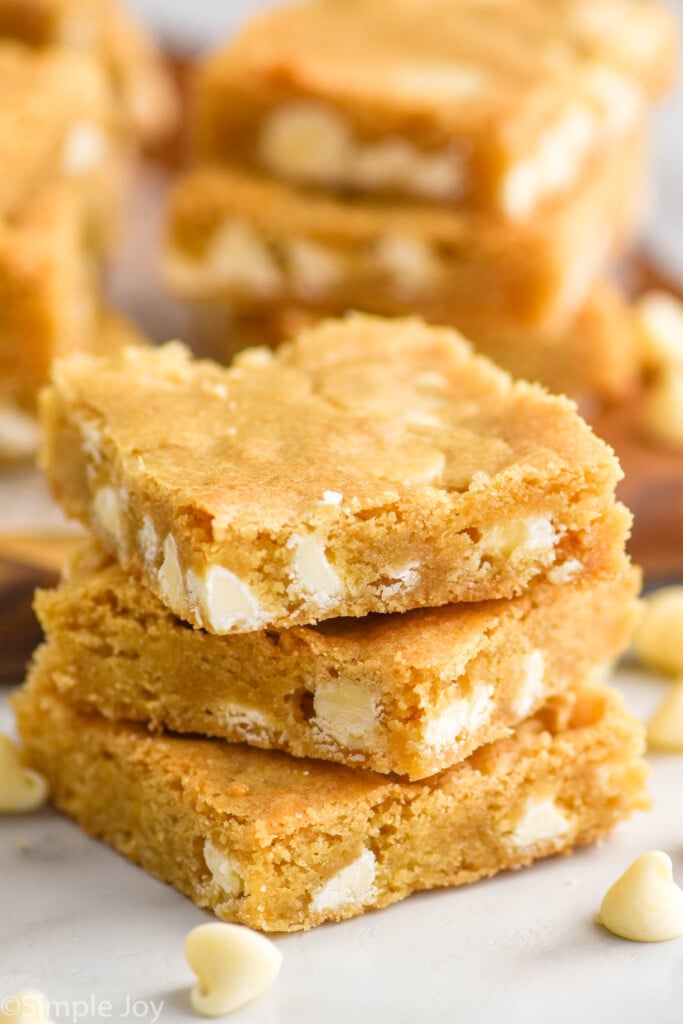Side view of a stack of blondie brownies and white chocolate chips