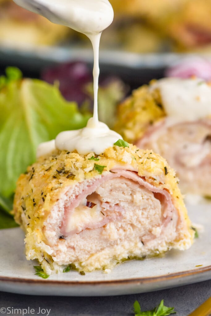 spoon dropping Chicken Cordon Bleu sauce on Chicken Cordon Bleu