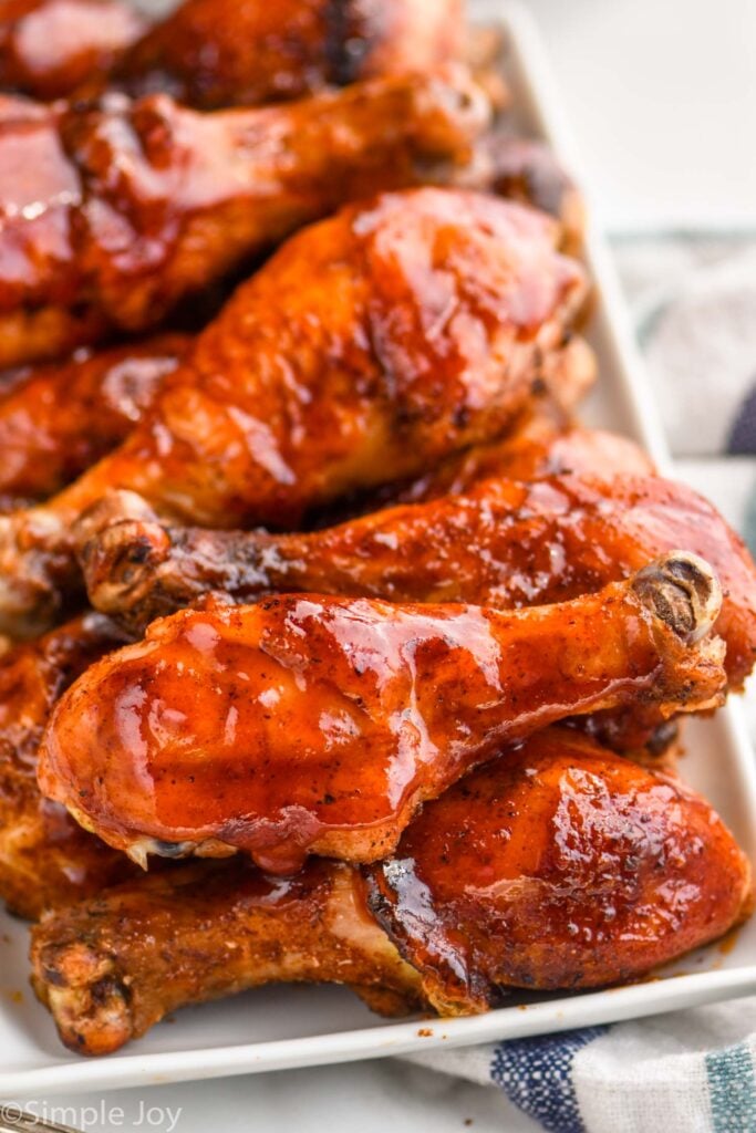 plate full of grilled chicken legs sitting on a striped napkin