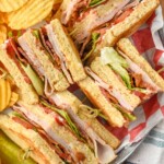 overhead view of club sandwich with chips and a pickle spear - 10