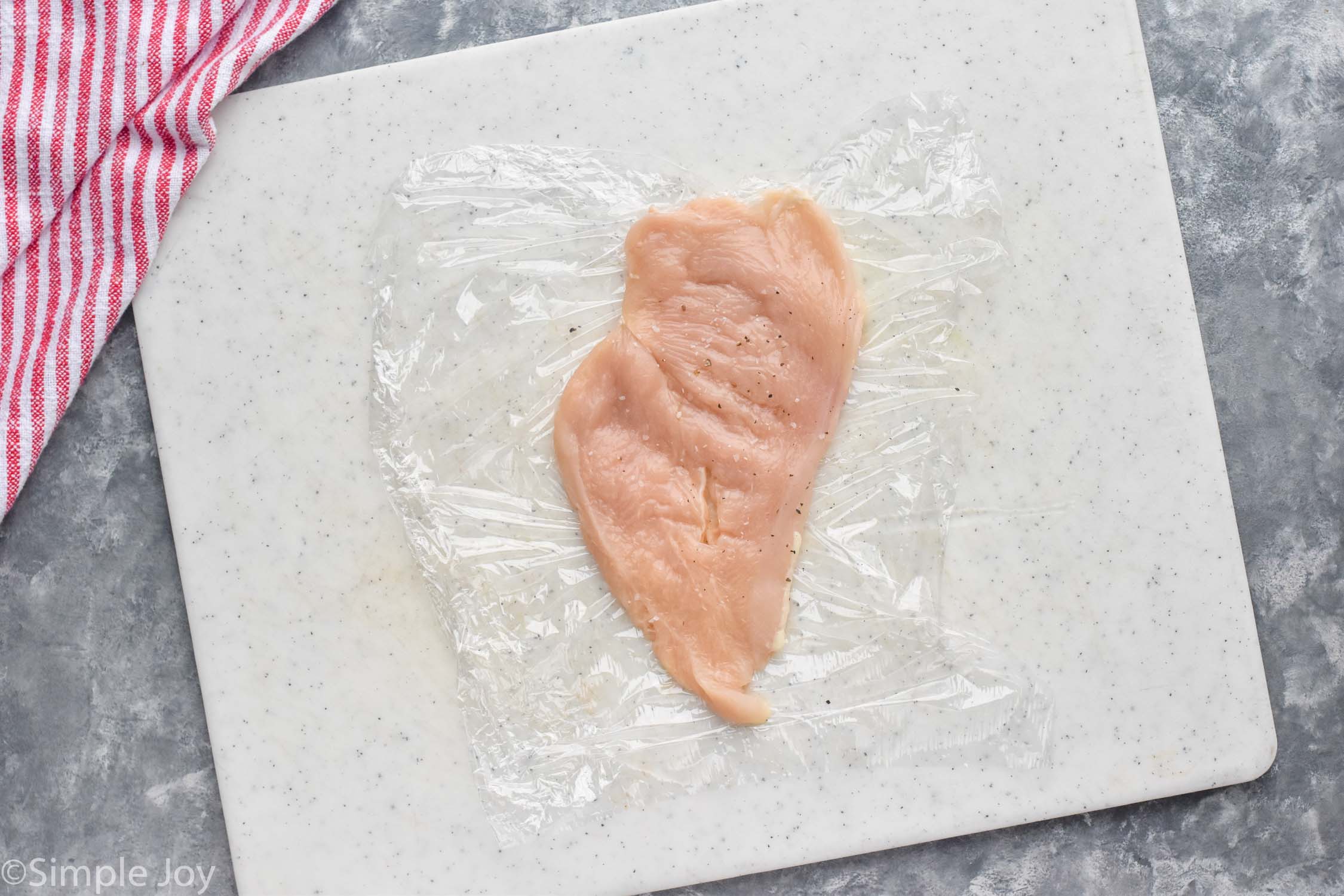 overhead view of chicken cutlet on cutting board to make Chicken Cordon Bleu