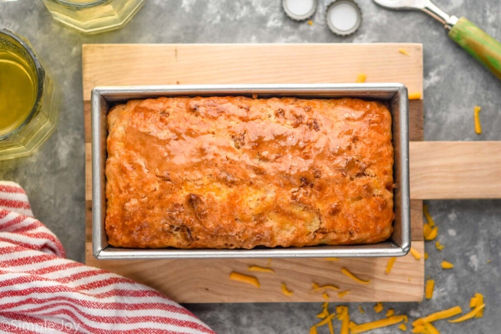 Overhead photo of a pan of Bacon Cheese Beer Bread on a wooden board