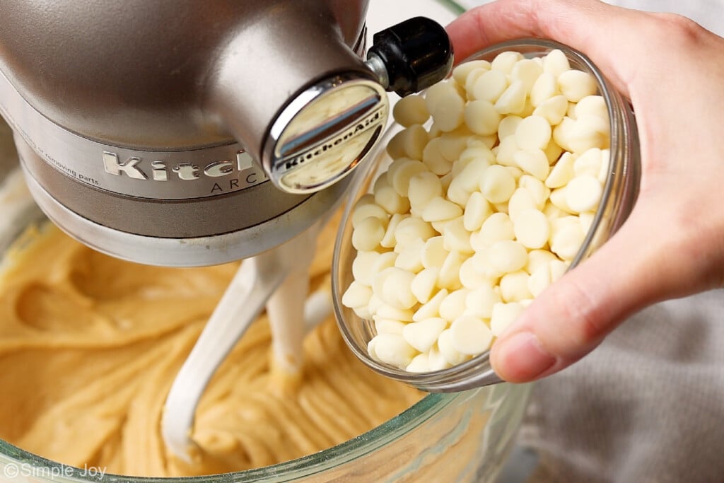 pouring white chocolate chips into a mixing bowl