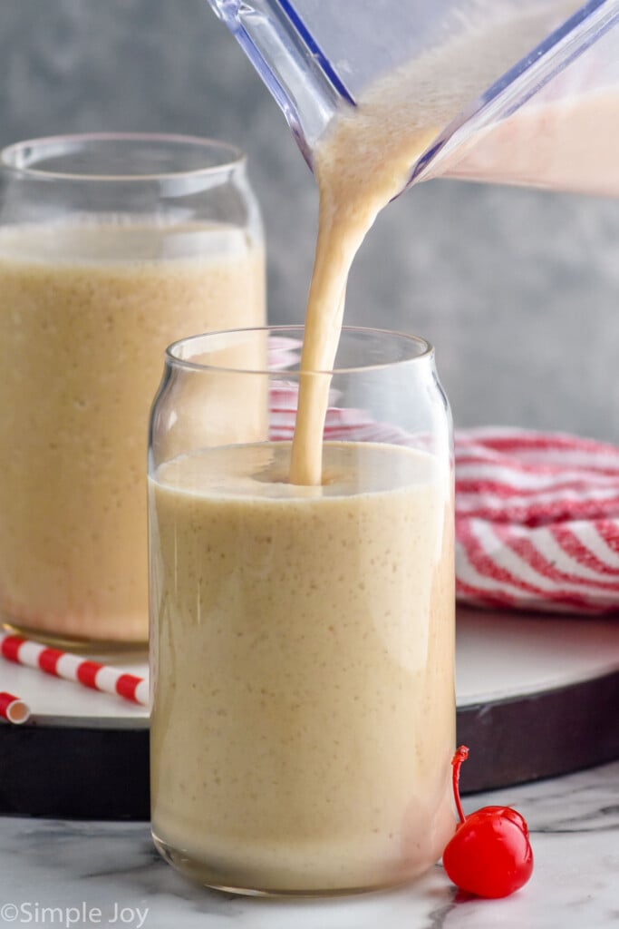 Side view of a blender of Bushwacker cocktail being poured into glasses