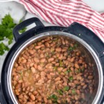 Pinterest graphic for Instant Pot Pinto Beans. Text says "Instant Pot Pinto Beans simplejoy.com" Image shows overhead of instant pot of pinto beans