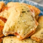 Close up photo of a plate of Mini Calzones with a bite taken out of the top Mini Calzone. - 21