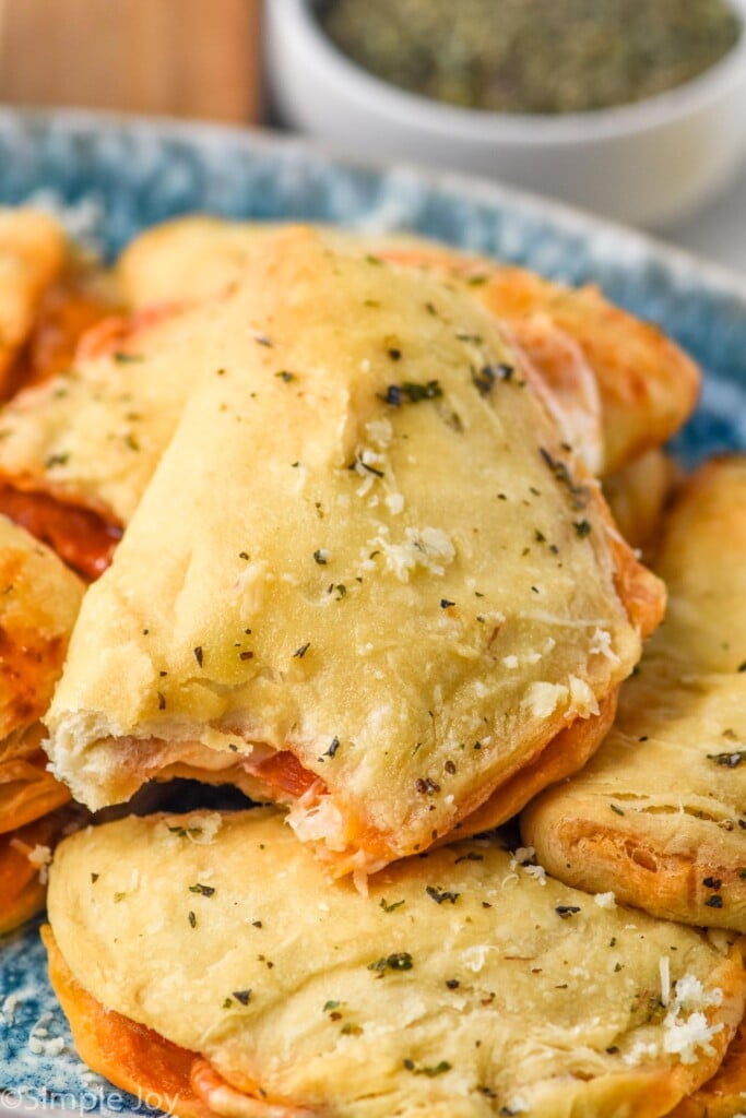 Close up photo of a plate of Mini Calzones with a bite taken out of the top Mini Calzone.