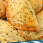 Pinterest graphic for Mini Calzones recipe. Image is close up photo of a plate of Mini Calzones. Text says, "Mini Calzones simplejoy.com"