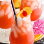 Pinterest graphic for Sex on the Beach recipe. Text says, "the best Sex on the Beach simplejoy.com." Close up photo of Sex on the Beach garnished with orange slice and cherry. Extra fruit and umbrellas beside glasses for garnish.